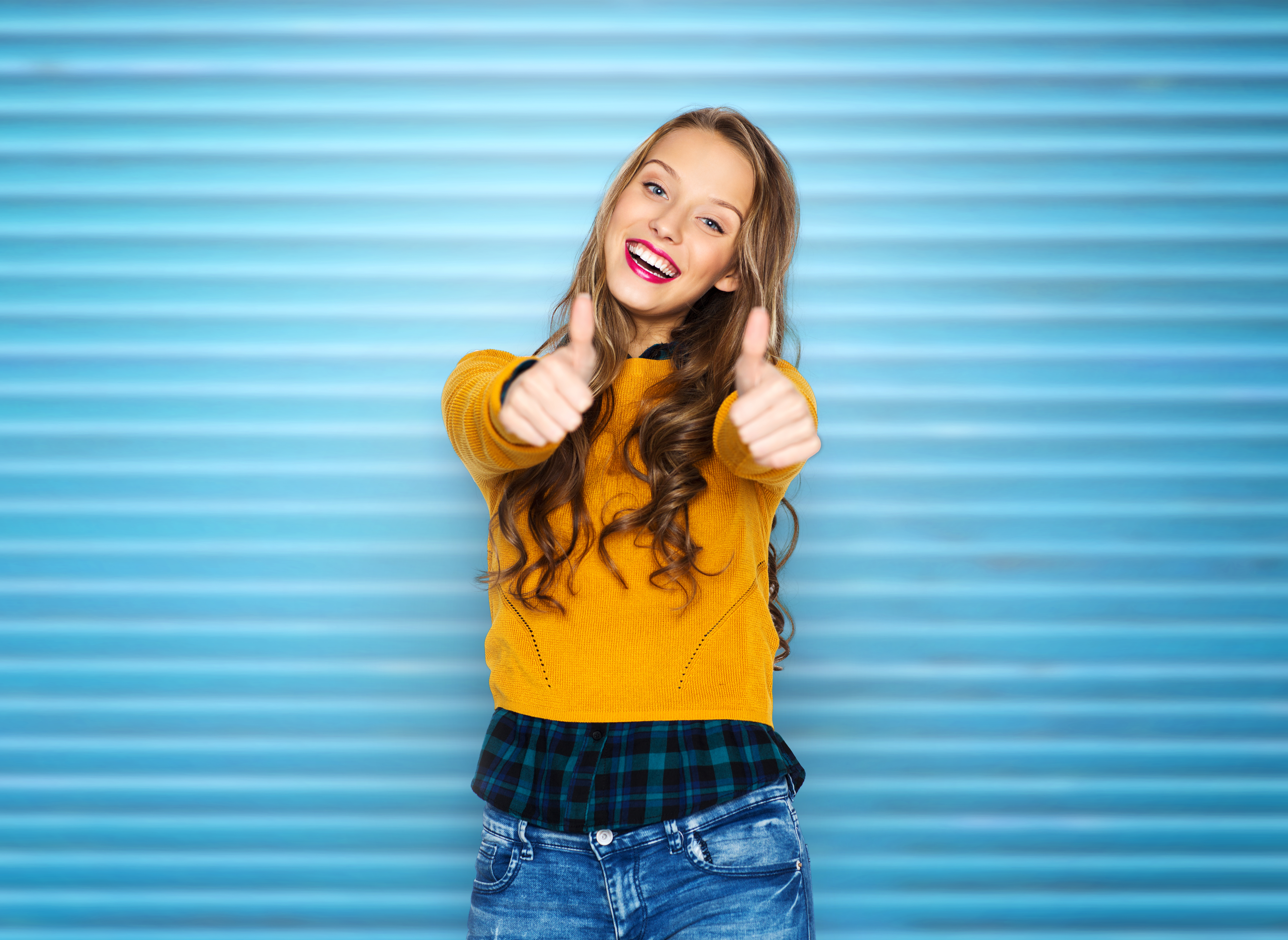 happy young woman or teen girl showing thumbs up