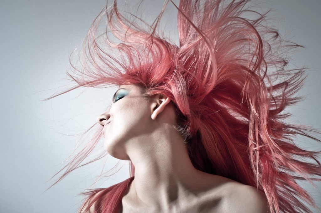 Person doing a Pink Hair Toss creating a feather effect