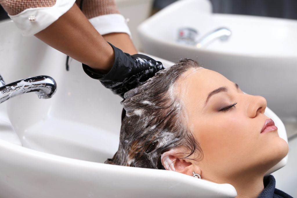 Woman having hair washed in salon.