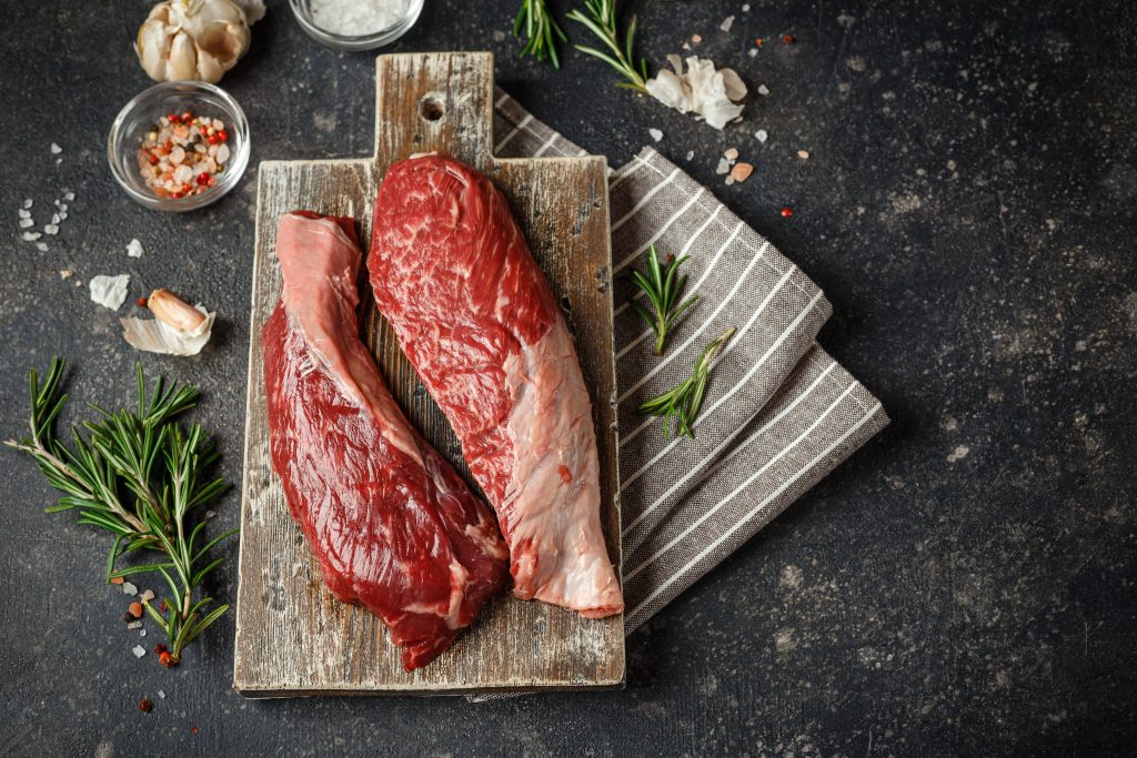 Two beef fillets on chopping board.