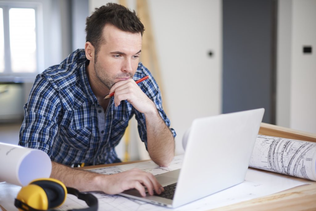 Man thinking while looking at laptop.