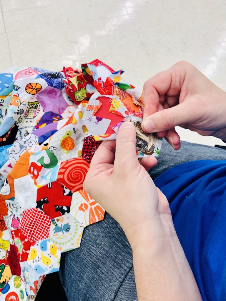 Person sewing patchwork.
