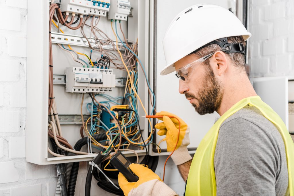 Electrician testing electrical fuse box.