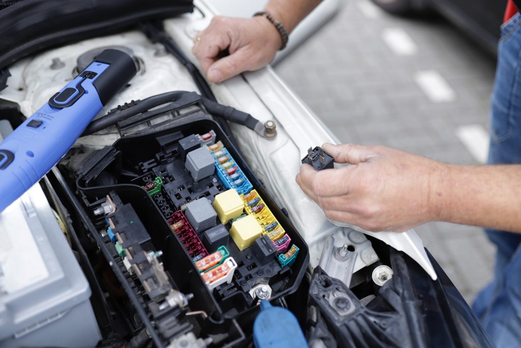 Hands working on electric car engine
