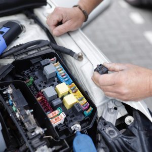 Hands working on electric car engine