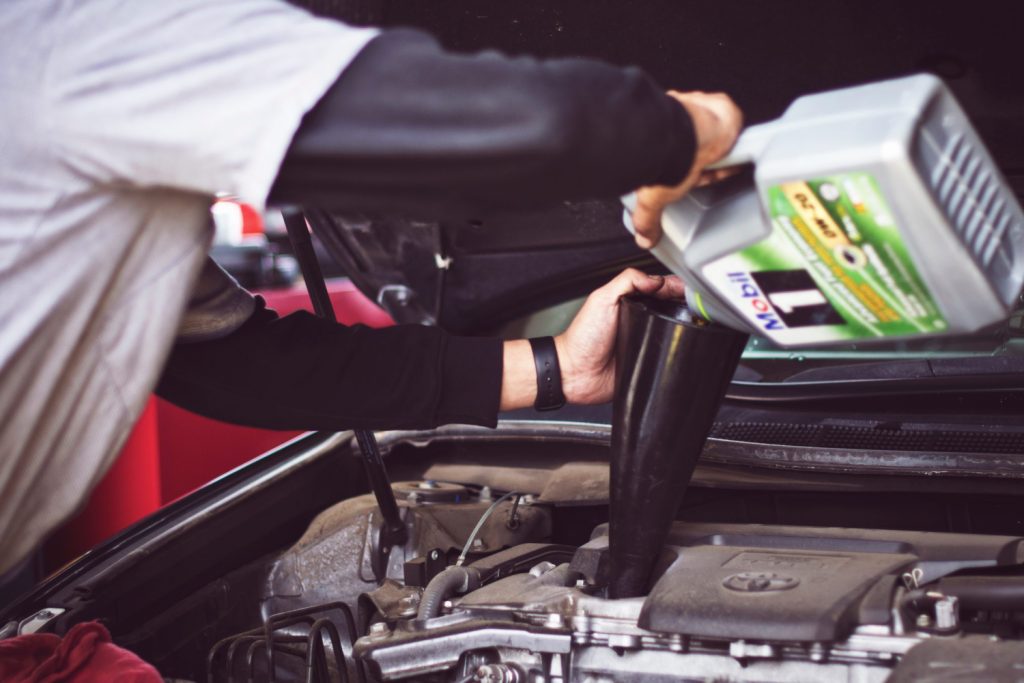 Pouring oil into car engine