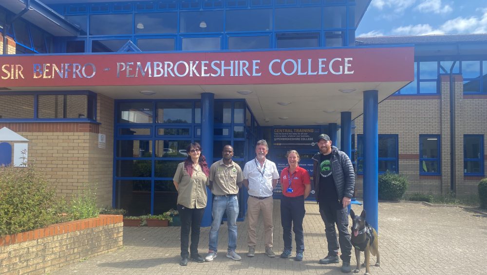 Dogs 4 Wildlife team with Pembrokeshire College Animal Care Tutors outside the College building.