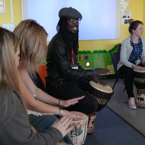 Lox with childcare learners patting on drums