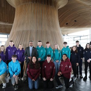 Competitors in the Senedd wearing hoodies and Vaughan Gething is centre