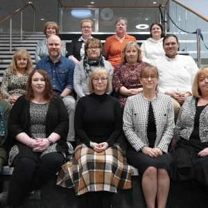 Group of staff sitting on steps.