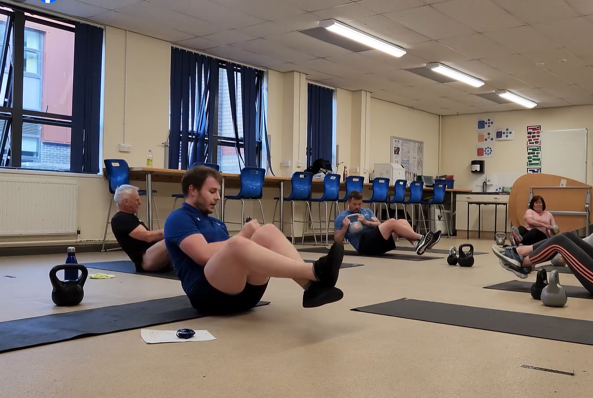Trainers sitting and lifting kettlebells