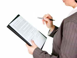 Person checking a document on a clipboard.