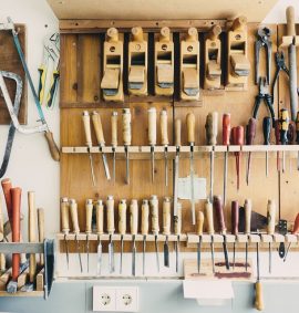 Traditional carpentry tools hanging on rack.