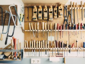 Traditional carpentry tools hanging on rack.