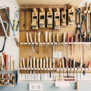 Traditional carpentry tools hanging on rack.