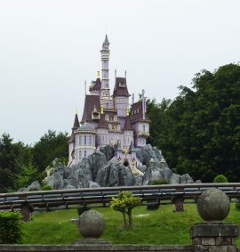 Miniature pink castle with rollercoaster track in foreground.