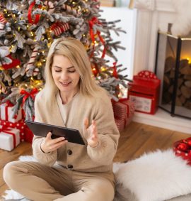 woman with tablet on the background of a Christmas tree.
