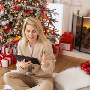 woman with tablet on the background of a Christmas tree.