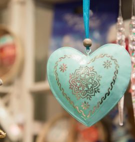 Christmas blue heart in fair kiosk with red handcrafted xmas decorations. Close up.