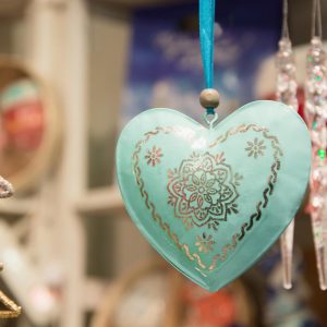 Christmas blue heart in fair kiosk with red handcrafted xmas decorations. Close up.