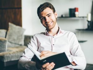 Businessman holding book and smiling