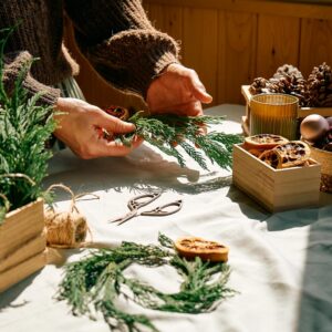 Hands making Christmas wreath.