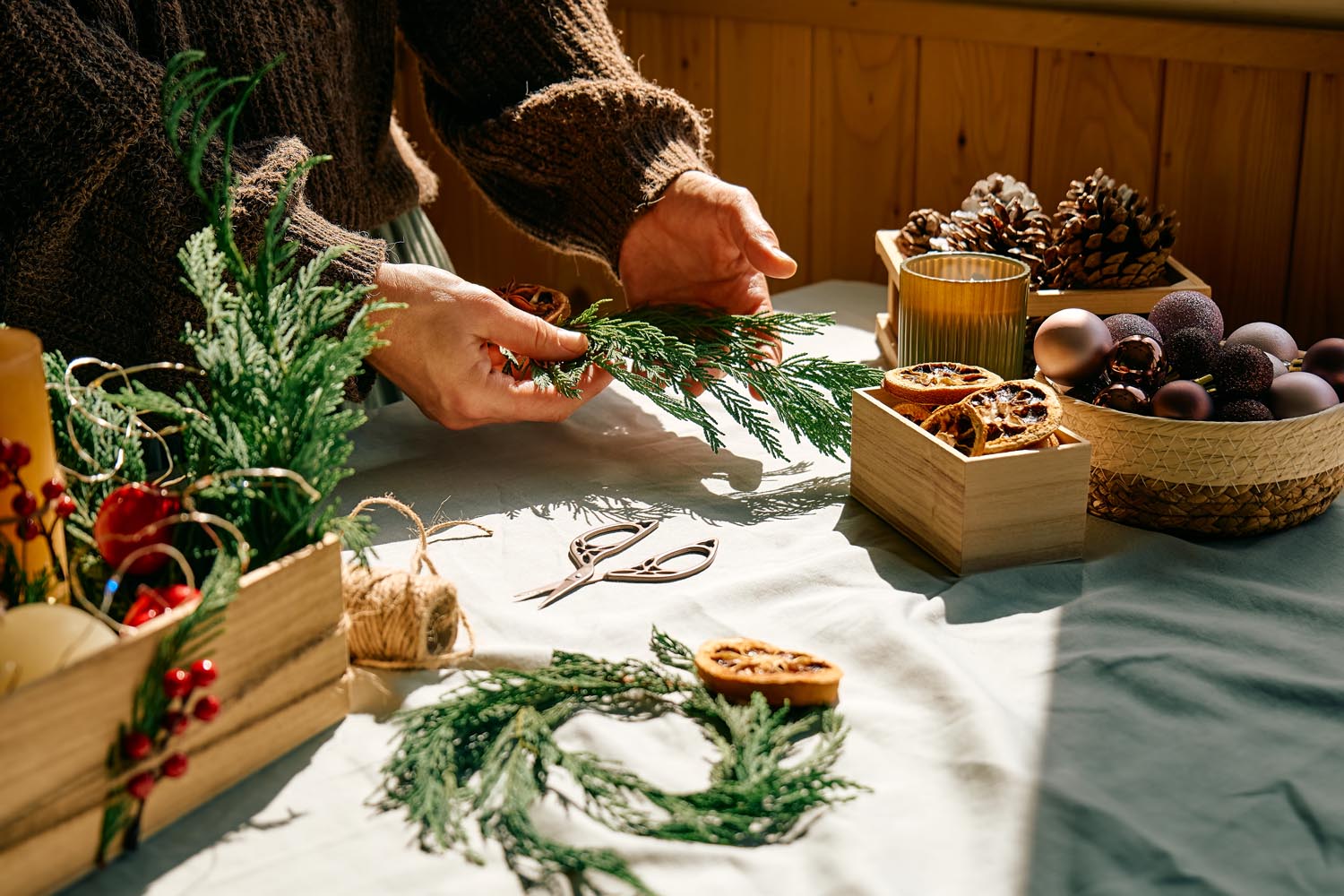 Hands making Christmas wreath.