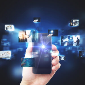Hand holding a smartphone with digital pictures in background.