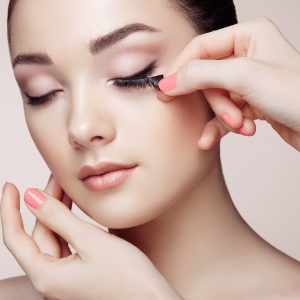 Eye lashes being applied to model.