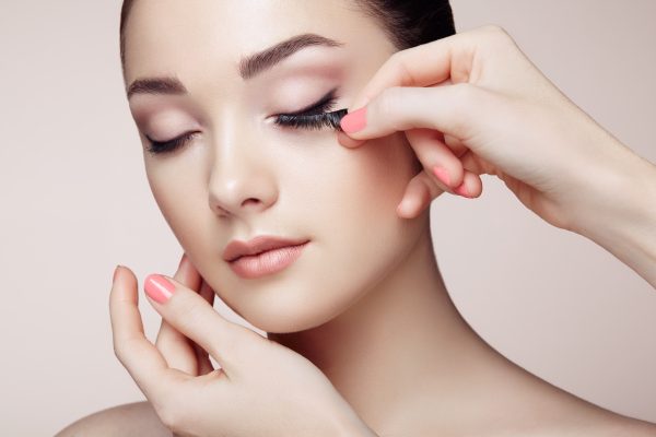 Eye lashes being applied to model.