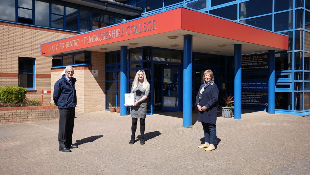 Michaela receiving certificate, outside College.