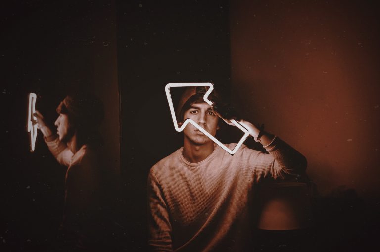 Man holding a neon arrow.