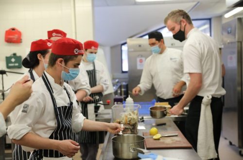 Two Chefs teaching catering students.