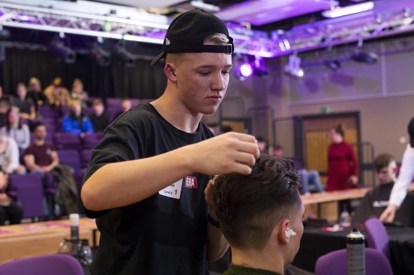 Jamie Lee styling hair in front of audience.