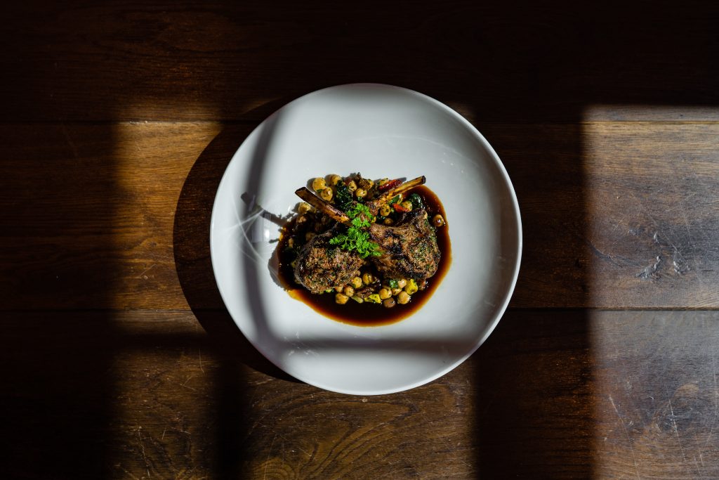 Plate with cooked food, lamb chops with chickpeas.