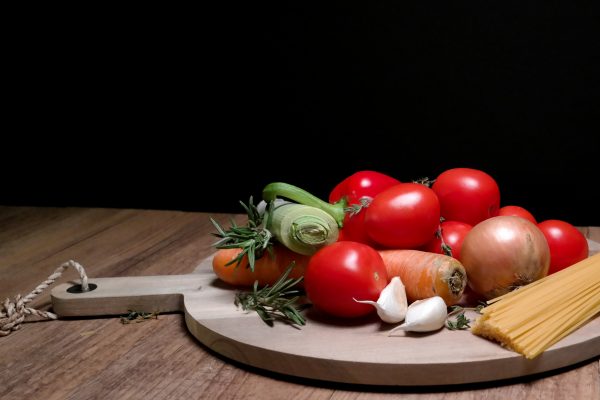 Hospitality Course Vegetables, herbs and garlic on chopping board.
