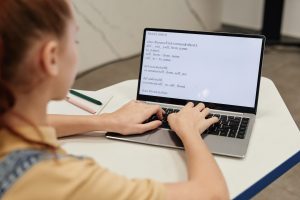 Girl computer coding on laptop.