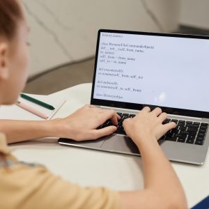 Girl computer coding on laptop.