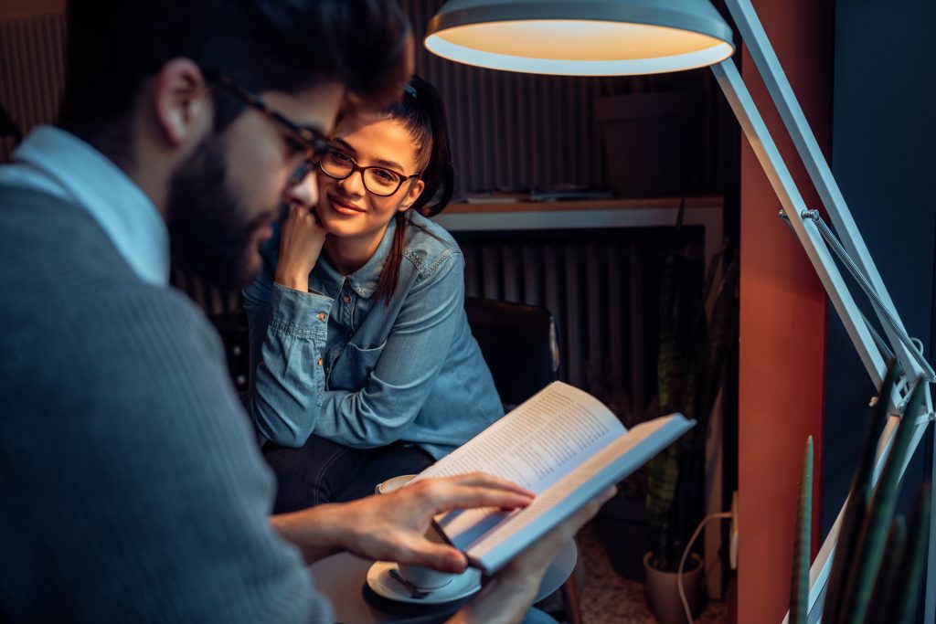 Couple studying in cosy coffee shop.