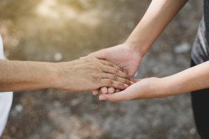 Cropped image of young hands holding an older hand.