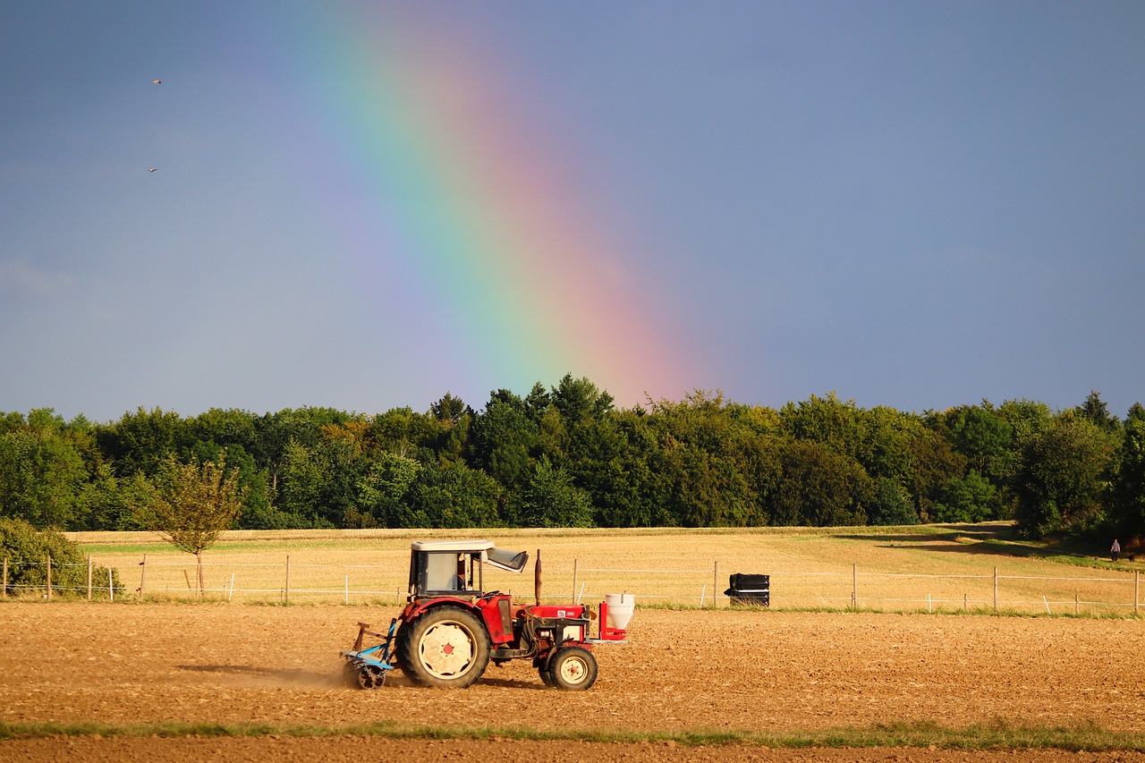 Tractor in field with a rainbow sky