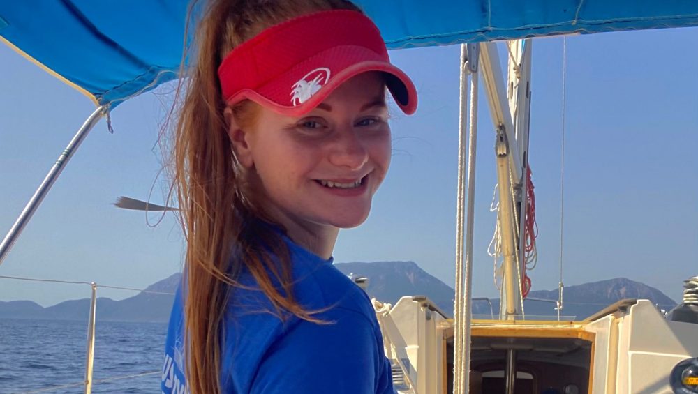 Lowri at helm of boat.