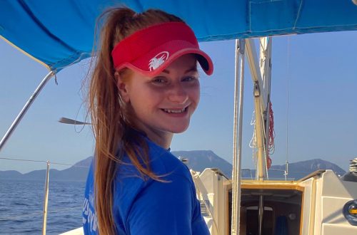 Lowri at helm of boat.