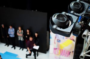 View of stage lighting with actors in background.