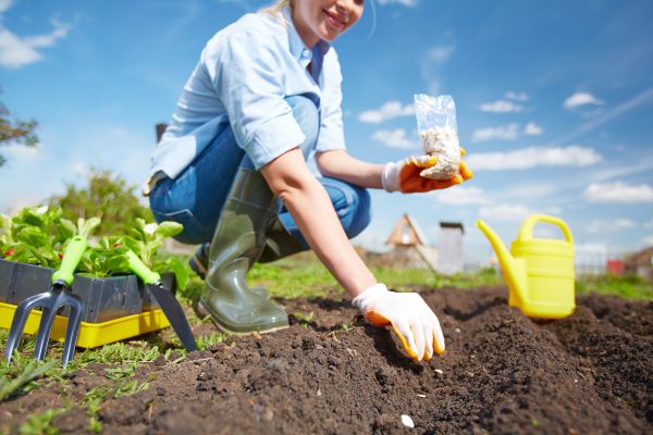 Land-based Countryside Course Lady planting seeds outside.