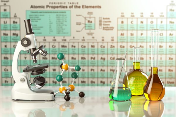 Microscope and glass flasks in front of periodic table.