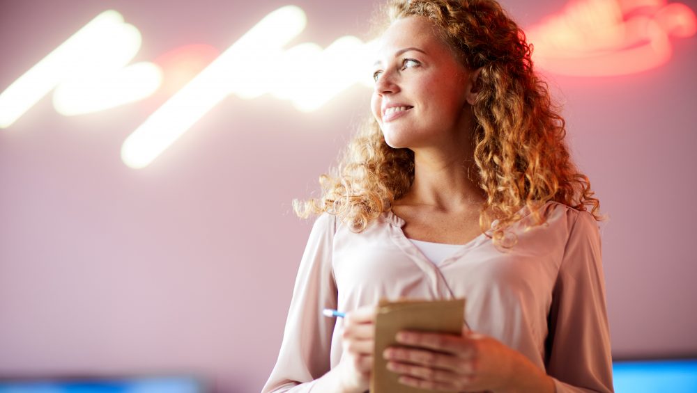 Smiling woman taking notes.