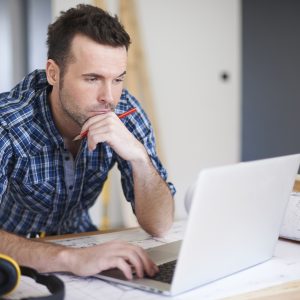 Man thinking while looking at laptop.