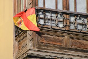 Wooden balcony flying the Spanish flag.