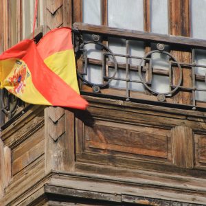 Wooden balcony flying the Spanish flag.